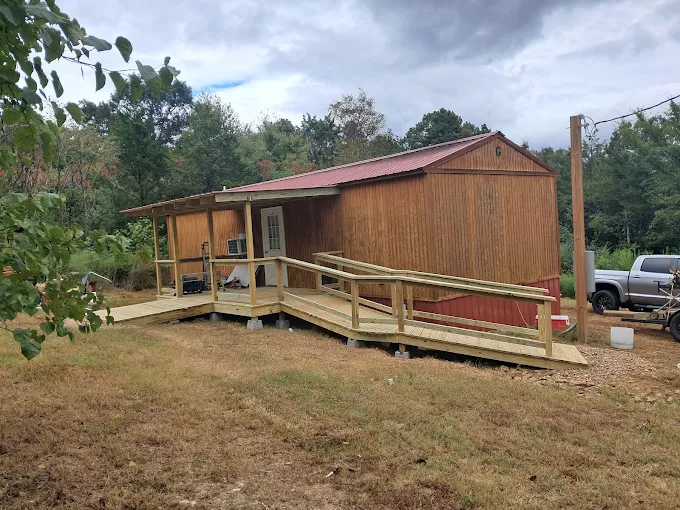 Wooden shed with wheelchair ramp in rural wooded setting