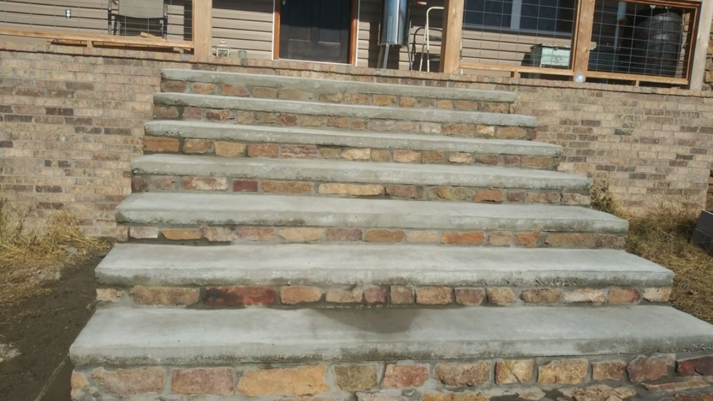Stone and concrete steps leading to a building with brick walls